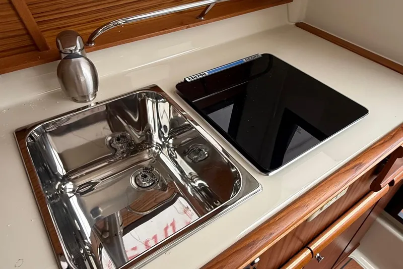 Slide: The Image of 2025 Ranger Tugs R-25 kitchen with stainless steel sink and modern cooktop. - 34
