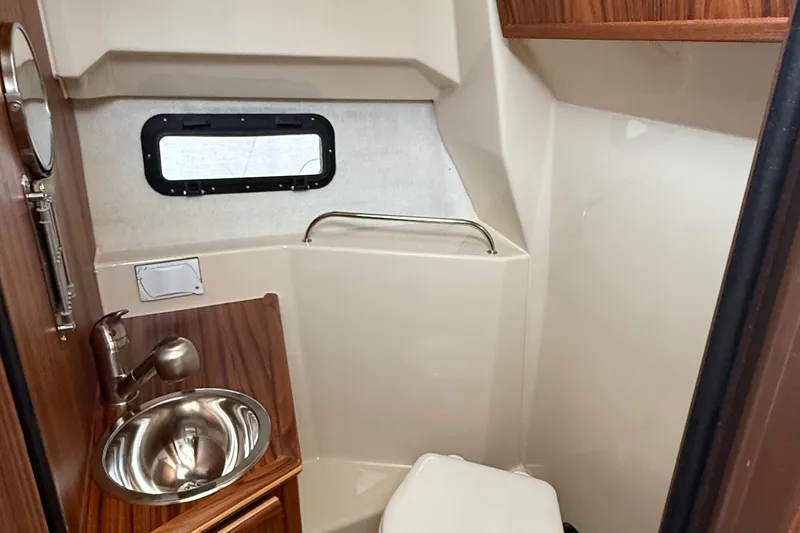 Slide: The Image of 2025 Ranger Tugs R-25 boat bathroom with sink, toilet, and window. - 42