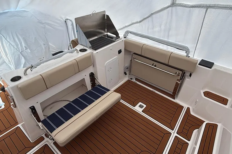 Slide: The Image of 2025 Ranger Tugs R-25 boat interior with seating and grill on teak deck. - 6