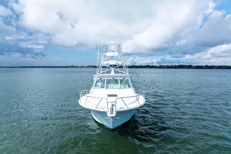 Slide: The Image of 2004 Cabo 40 Hardtop Express yacht on open water under cloudy sky. - 2