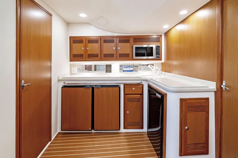 Slide: The Image of 2004 Cabo 40 Hardtop Express yacht interior kitchen with wood cabinetry and modern appliances. - 22