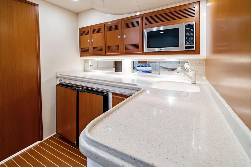 Slide: The Image of Luxurious 2004 Cabo 40 Hardtop Express yacht kitchen with modern amenities and sleek design. - 24