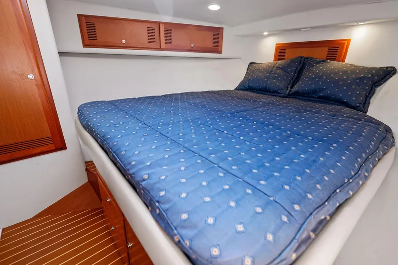 Slide: The Image of Luxurious cabin interior of 2004 Cabo 40 Hardtop Express with cozy bed and wooden accents. - 30