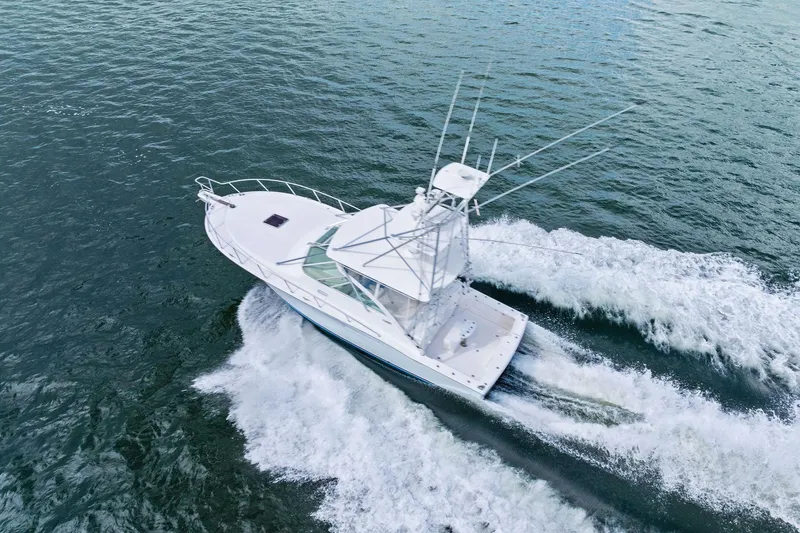 Slide: The Image of 2004 Cabo 40 Hardtop Express yacht cruising on open water, aerial view. - 43
