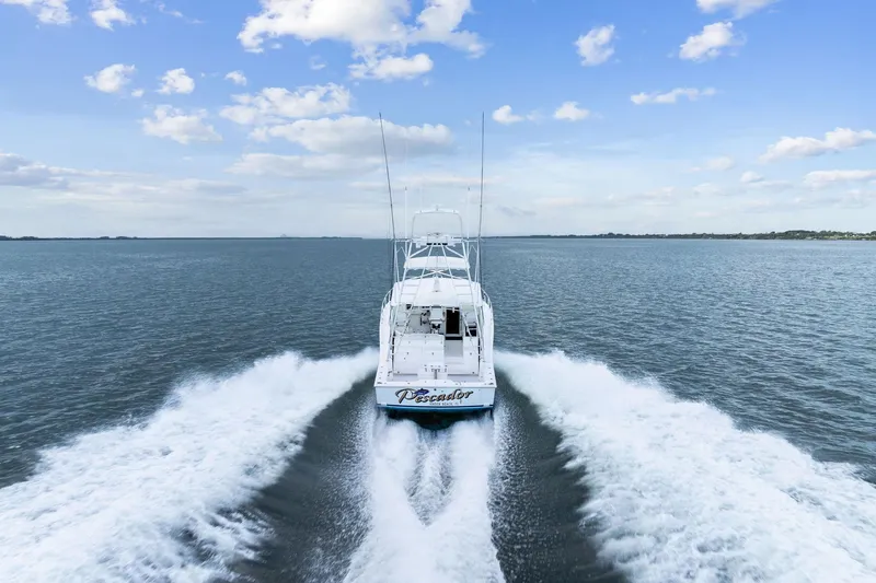 Slide: The Image of 2004 Cabo 40 Hardtop Express cruising on open water under a blue sky. - 44