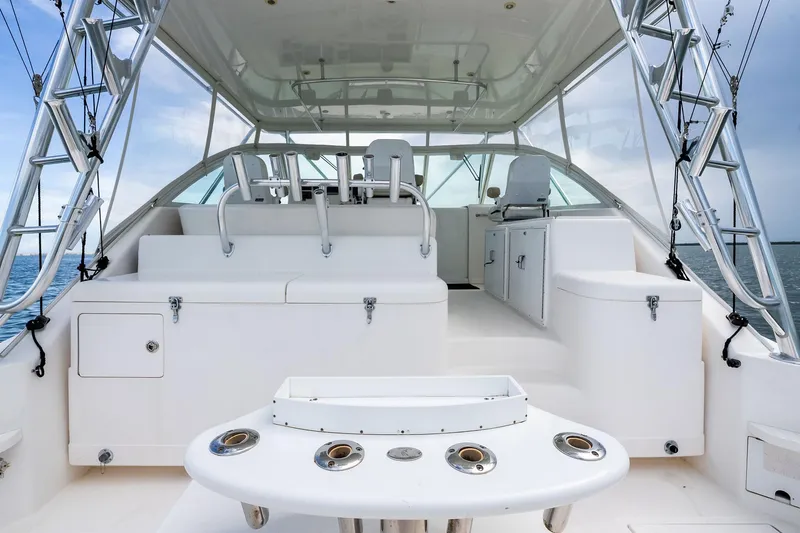 Slide: The Image of 2004 Cabo 40 Hardtop Express boat interior with seating and fishing rod holders. - 7