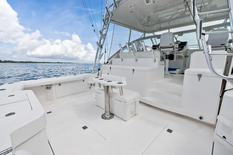 Slide: The Image of 2004 Cabo 40 Hardtop Express yacht deck with seating and fishing rod holders. - 8