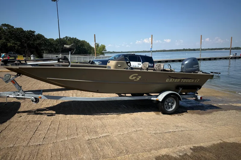 Slide: The Image of 2020 G3 Gator Tough 17 SC boat on trailer by a lake. - 16