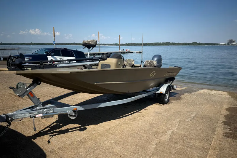 Slide: The Image of 2020 G3 Gator Tough 17 SC boat on trailer by a lake. - 18