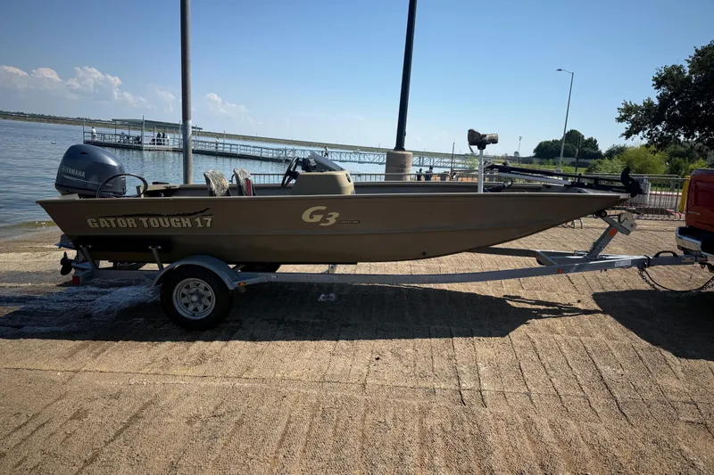 Slide: The Image of 2020 G3 Gator Tough 17 SC boat on trailer by a lake. - 3