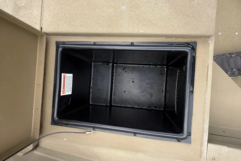 Slide: The Image of Open storage compartment in 2020 G3 Gator Tough 17 SC boat, showing interior with warning label. - 34