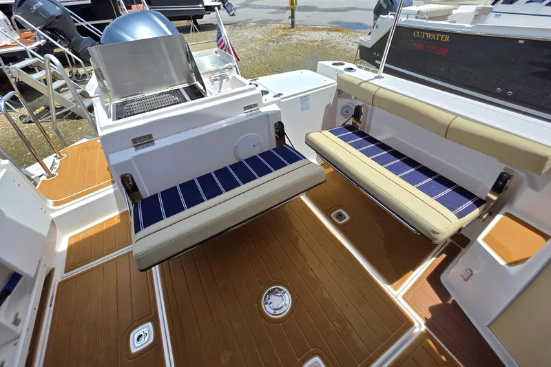 Slide: The Image of Interior view from a 2020 Ranger Tugs R27LE boat, showcasing the deck and surrounding marina. - 11