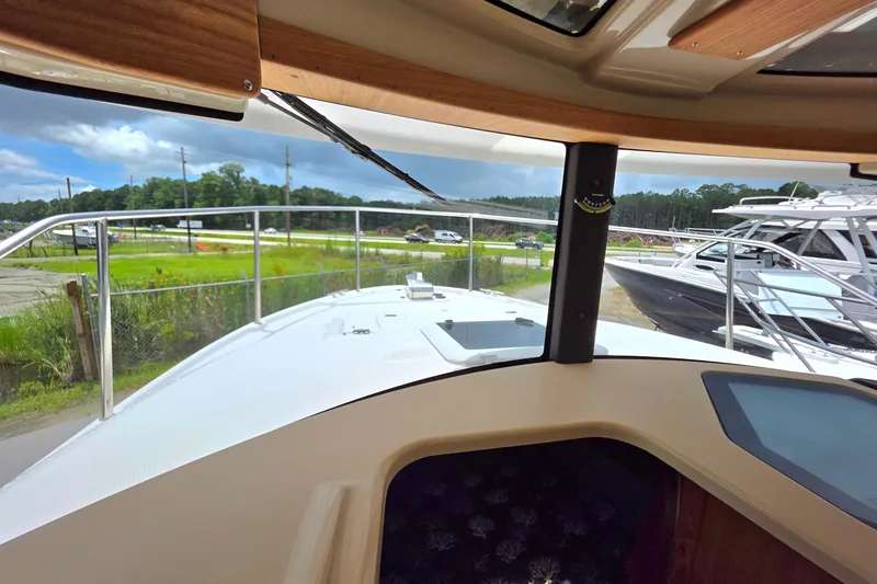 Slide: The Image of Interior of 2020 Ranger Tugs R27LE boat with wood accents and navigation equipment. - 14