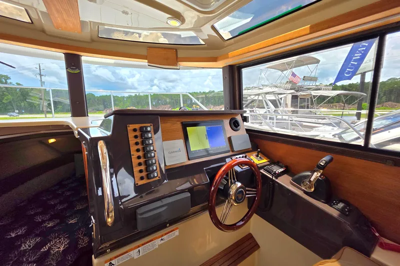 Slide: The Image of 2020 Ranger Tugs R27LE interior with kitchen, sink, stove, and seating area. - 15