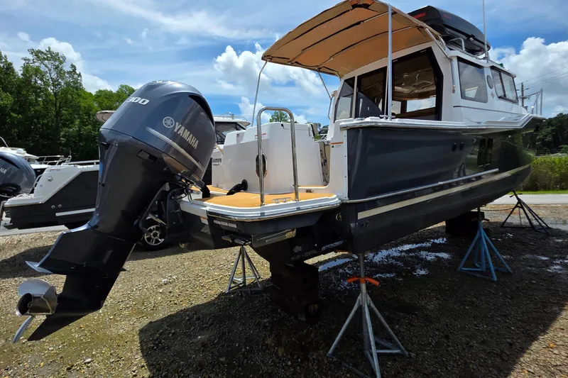 Slide: The Image of 2020 Ranger Tugs R27LE boat on stands, displayed outdoors under cloudy sky. - 5