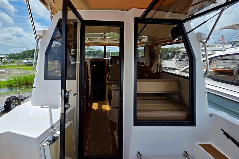 Slide: The Image of 2020 Ranger Tugs R27LE boat deck with foldable seating and grill. - 8