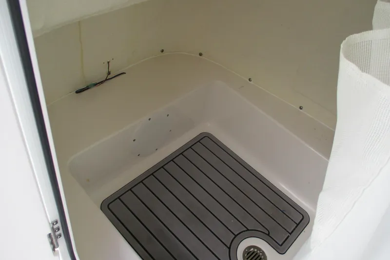 Slide: The Image of 2023 Tidewater 210 LXF boat interior compartment with drainage and wiring. - 12