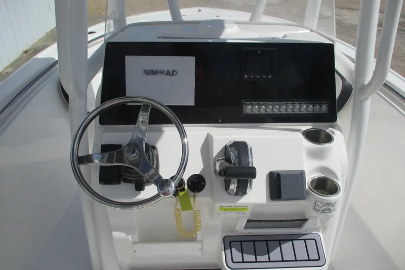 Slide: The Image of 2023 Tidewater 210 LXF boat dashboard with steering wheel and Simrad display. - 14