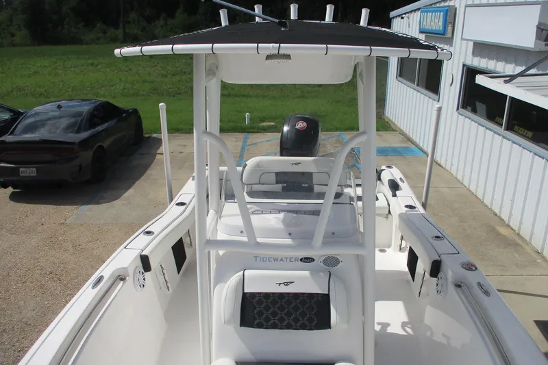 Slide: The Image of 2023 Tidewater 210 LXF boat with T-top, parked near a building. - 15