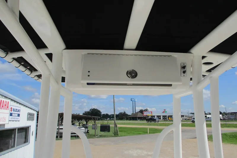 Slide: The Image of 2023 Tidewater 210 LXF boat T-top with storage compartment, outdoor dealership view. - 22