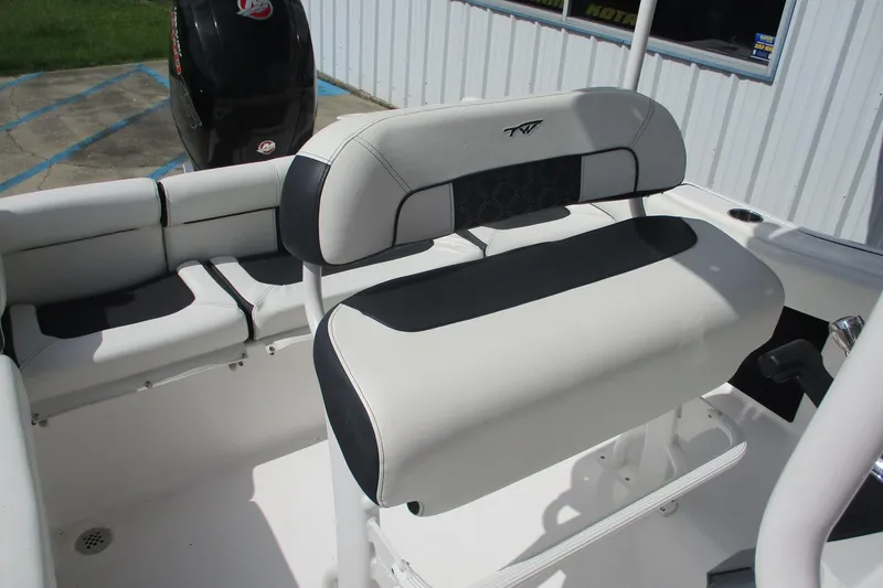 Slide: The Image of 2023 Tidewater 210 LXF boat interior with cushioned seating and motor. - 24