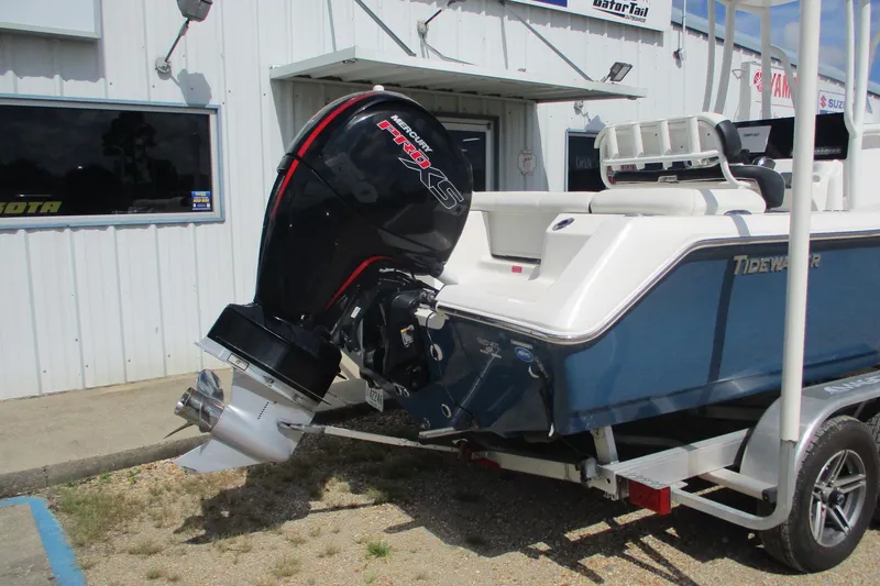 Slide: The Image of 2023 Tidewater 210 LXF boat with Mercury engine on trailer, parked outside a building. - 3