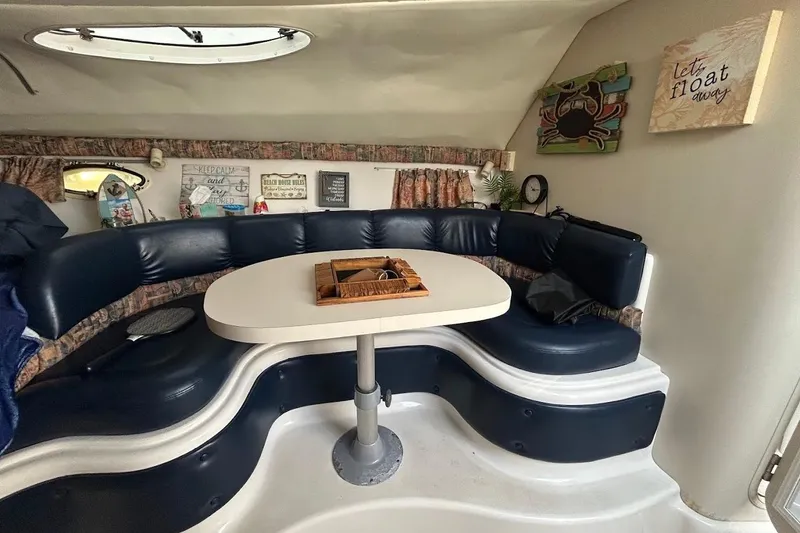 Slide: The Image of 1998 Chris-Craft 320 Express Cruiser interior with navy seating and nautical decor. - 10