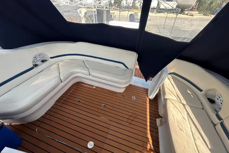 Slide: The Image of 1998 Chris-Craft 320 Express Cruiser interior with white seating and wooden flooring. - 15