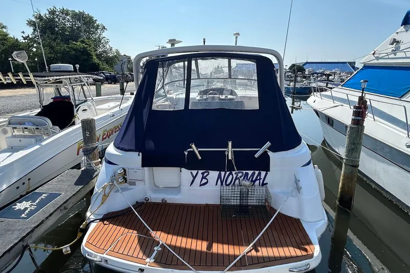 Slide: The Image of 1998 Chris-Craft 320 Express Cruiser docked at marina, rear view with cover. - 2