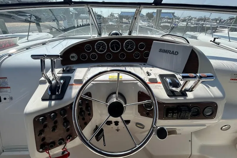 Slide: The Image of 1998 Chris-Craft 320 Express Cruiser helm with steering wheel and control panel. - 4