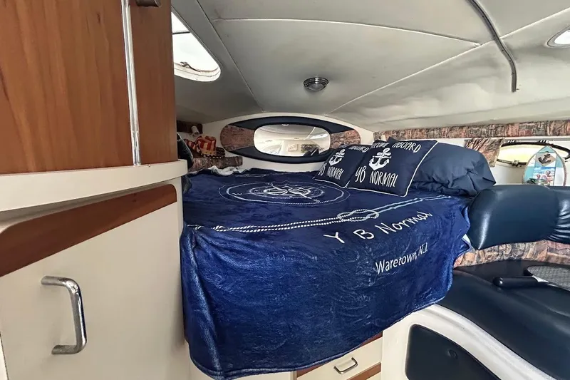 Slide: The Image of Interior cabin of 1998 Chris-Craft 320 Express Cruiser with cozy bed and nautical decor. - 9