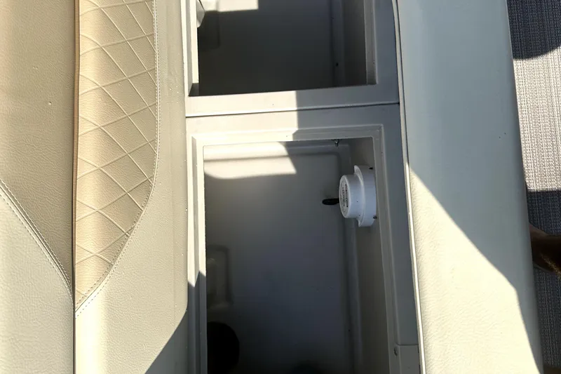 Slide: The Image of 2021 Veranda Vista 22RC boat storage compartment with beige cushioned seating. - 15