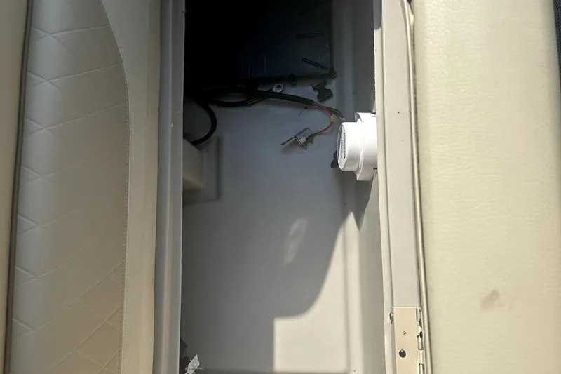 Slide: The Image of Storage compartment in a 2021 Veranda Vista 22RC boat, featuring wiring and a white component. - 16