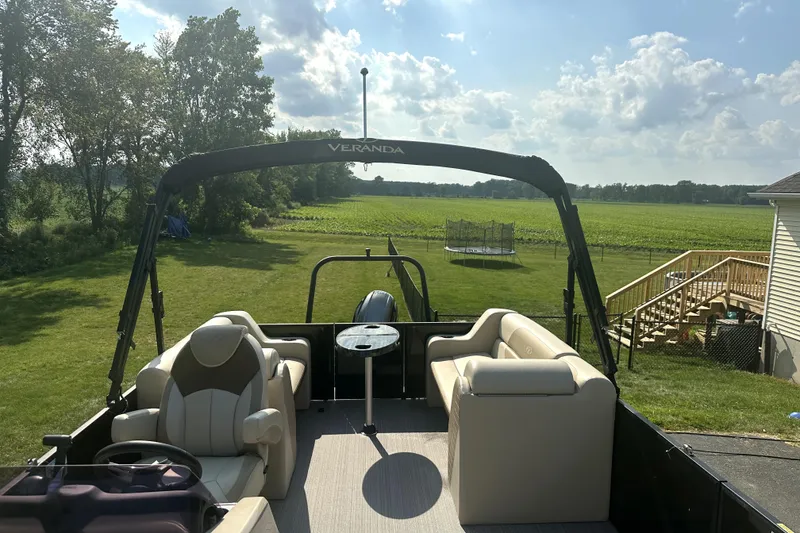 Slide: The Image of 2021 Veranda Vista 22RC pontoon boat parked in a scenic rural backyard. - 19