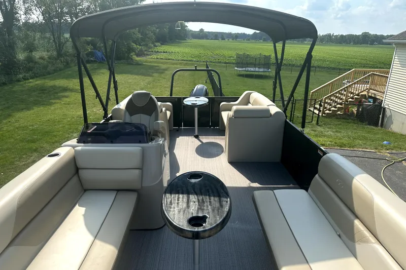 Slide: The Image of 2021 Veranda Vista 22RC pontoon boat with spacious seating and canopy in a grassy yard. - 23