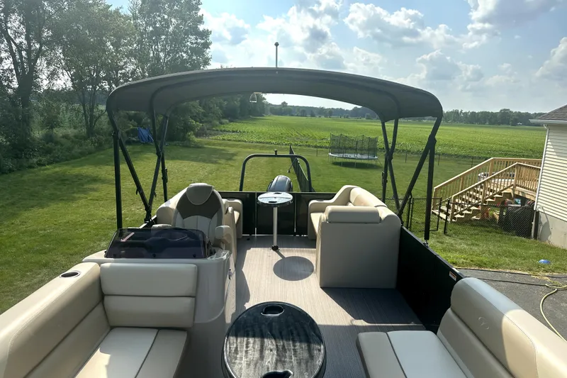 Slide: The Image of 2021 Veranda Vista 22RC pontoon boat with canopy, parked in a lush green yard. - 30