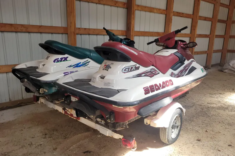 Slide: The Image of 1998 SkiDoo GTX jet skis on trailer in wooden shed. - 2