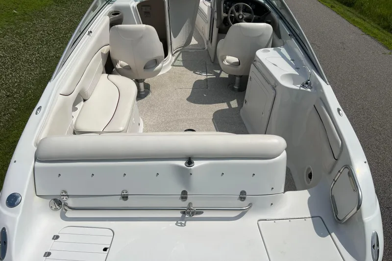 Slide: The Image of 2003 Crownline 230 BR boat interior with white seating and steering console. - 2