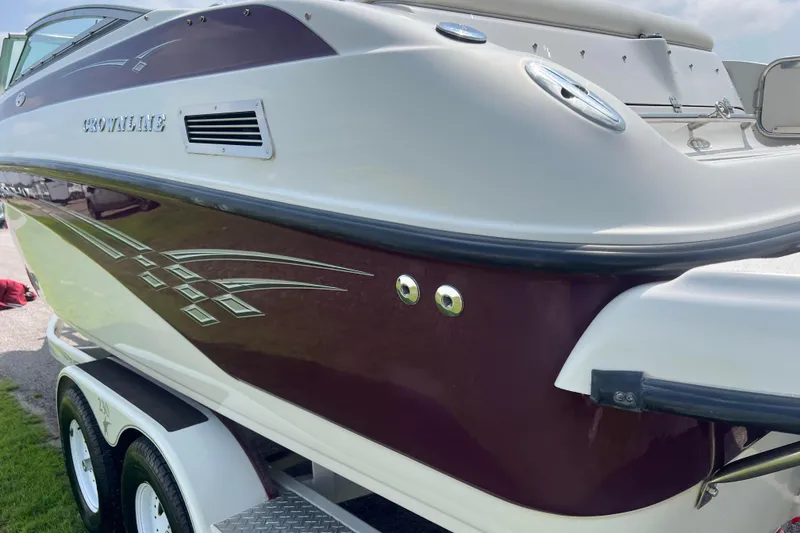 Slide: The Image of 2003 Crownline 230 BR boat on trailer, featuring sleek maroon and white design. - 20