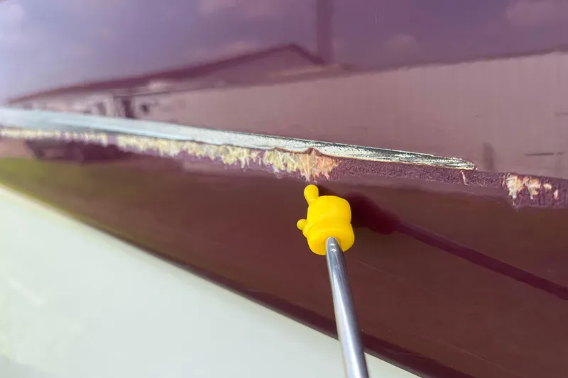 Slide: The Image of Close-up of 2003 Crownline 230 BR boat with visible hull damage. - 24