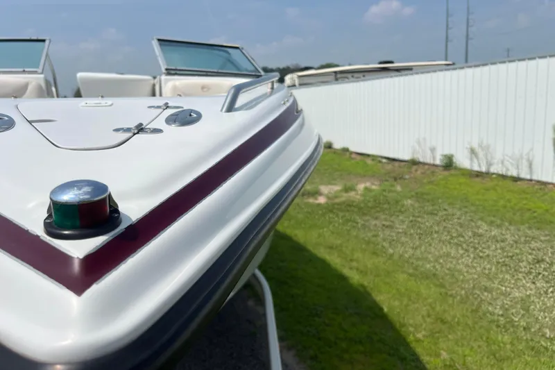 Slide: The Image of 2003 Crownline 230 BR boat bow with navigation light, parked on grass. - 27