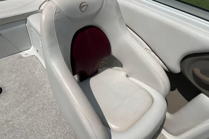 Slide: The Image of 2003 Crownline 230 BR boat interior with white leather seat and carpeted floor. - 40