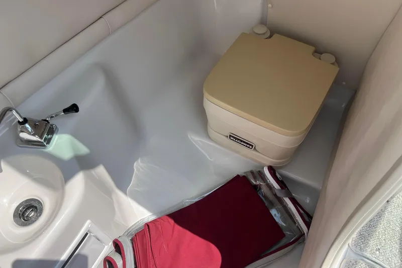 Slide: The Image of 2003 Crownline 230 BR boat interior with portable toilet and sink. - 45