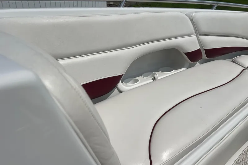Slide: The Image of 2003 Crownline 230 BR boat interior with white and maroon seating and cup holders. - 50