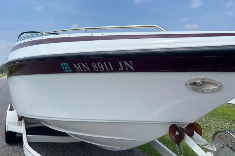 Slide: The Image of 2003 Crownline 230 BR boat on trailer, registration MN 8911 JN, parked on roadside. - 9