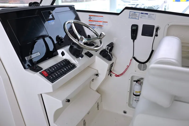 Slide: The Image of 2024 Pursuit DC 326 Dual Console helm with steering wheel, controls, and navigation equipment. - 13
