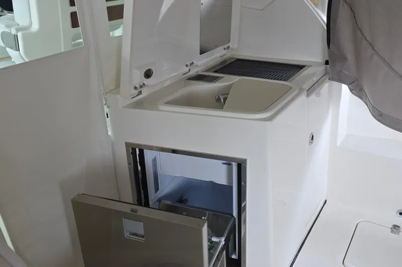 Slide: The Image of 2024 Pursuit DC 326 Dual Console boat interior with kitchenette and storage. - 20
