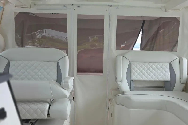 Slide: The Image of 2024 Pursuit DC 326 Dual Console interior with luxurious white seating and quilted design. - 21