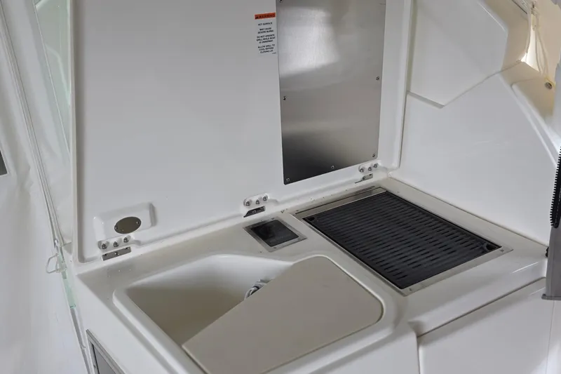 Slide: The Image of 2024 Pursuit DC 326 Dual Console boat interior with sink and grill setup. - 25