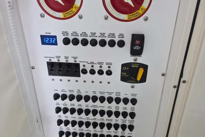 Slide: The Image of Control panel of 2024 Pursuit DC 326 Dual Console boat, featuring various switches and battery indicators. - 26